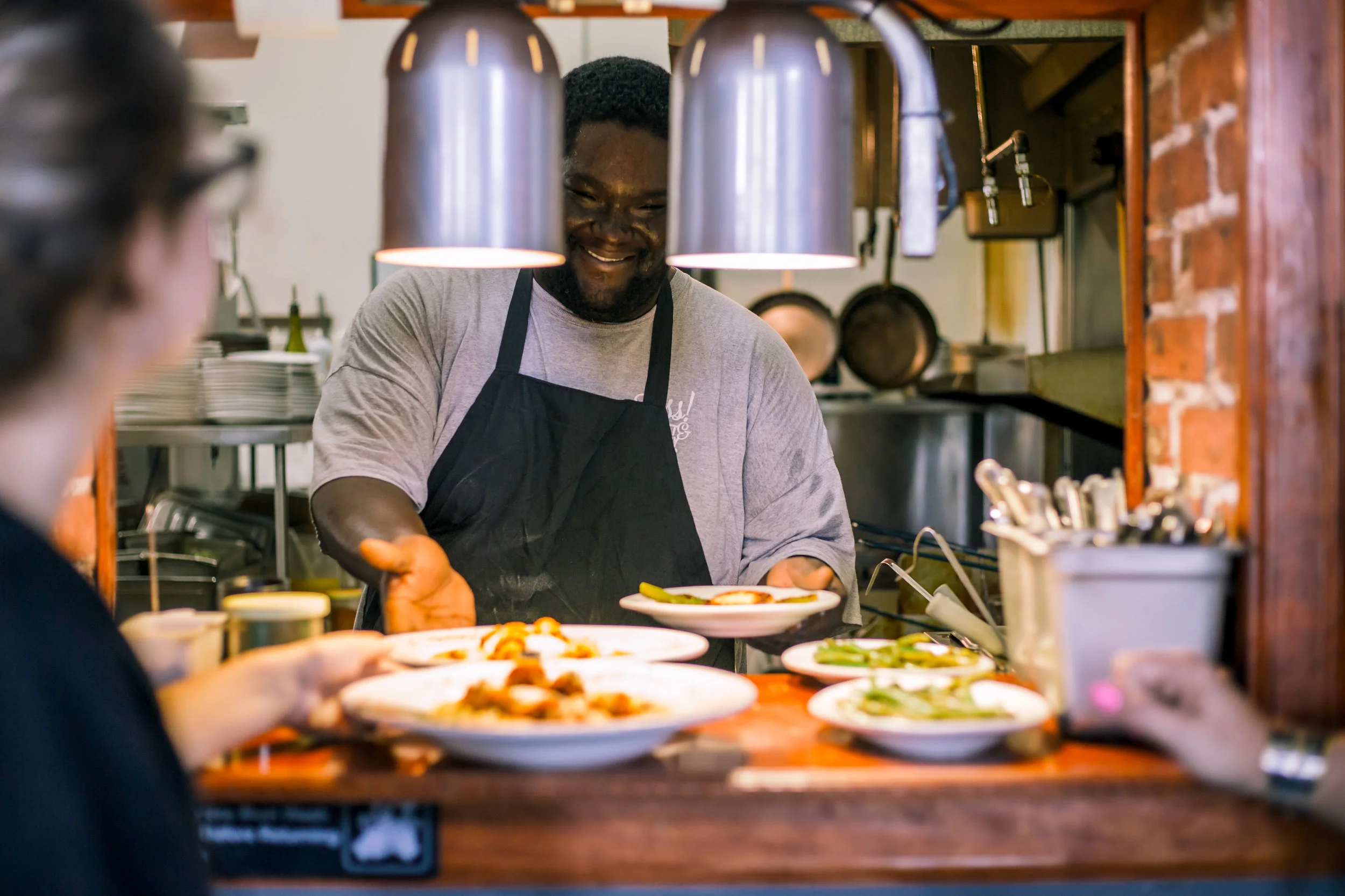 Chef carefully plating dishes in the Sass! kitchen